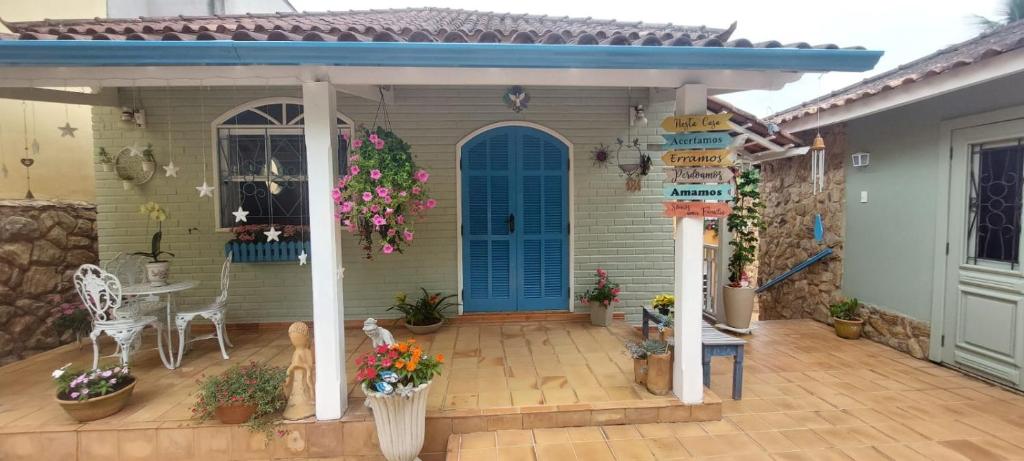 a house with a blue door and a patio at Pousada das Flores in Conservatória