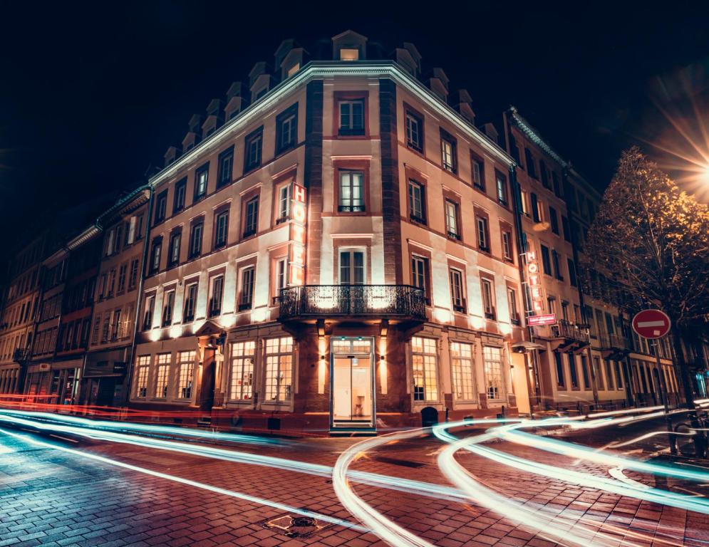 a large building on a city street at night at Hotel Saint Augustin in Strasbourg