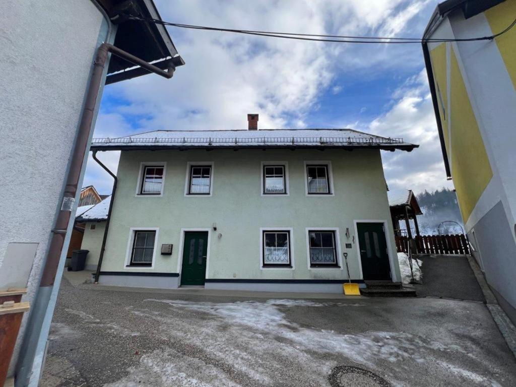 a white house with green doors on a street at Haus Lüftleck in Lunz am See