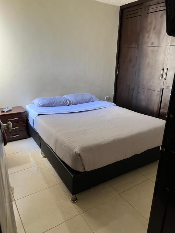 Un dormitorio con una cama con almohadas azules. en Mirador Inn, en Pasto