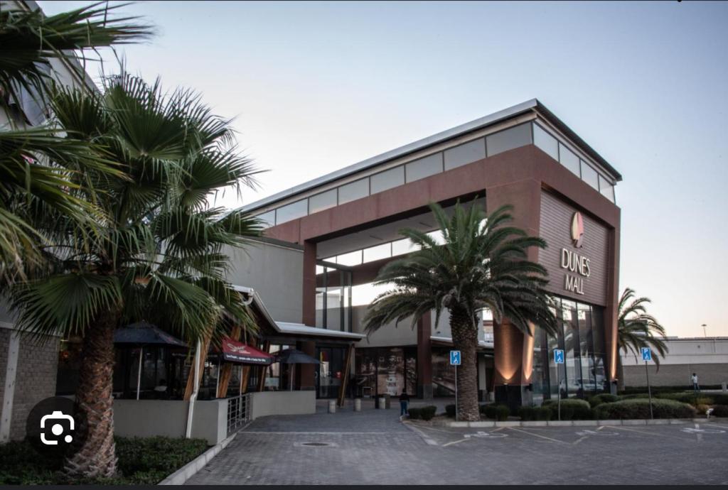 un gran edificio con palmeras delante en Euphorie, en Walvis Bay