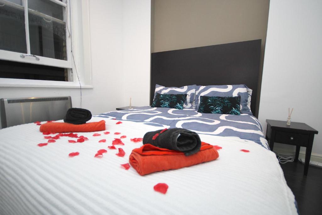 - un lit avec des cœurs rouges sur les draps dans l'établissement Chic Flat in Oxford Circus, à Londres