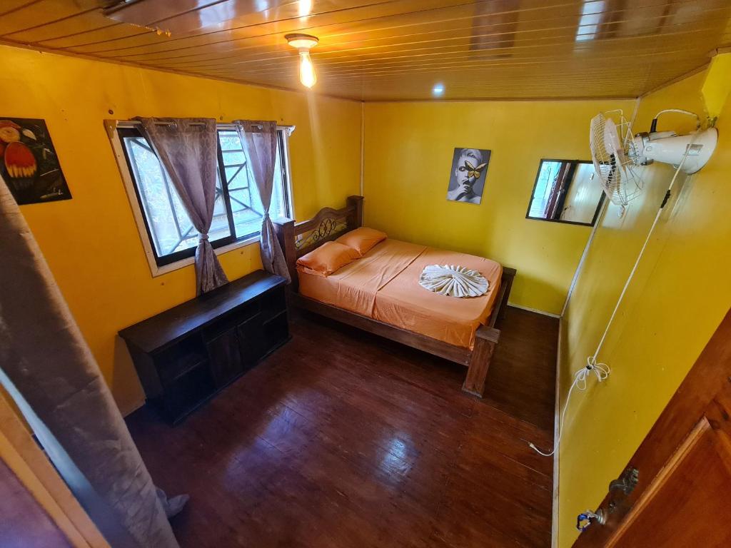 een slaapkamer met een bed in een gele kamer bij Hostel Yinary in Drake