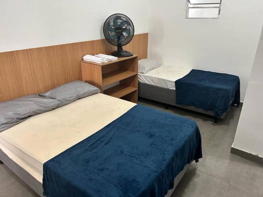 um quarto com 2 camas e uma ventoinha em Studio Zona norte SP - proximo Expo Center Norte Vila Guilherme em São Paulo