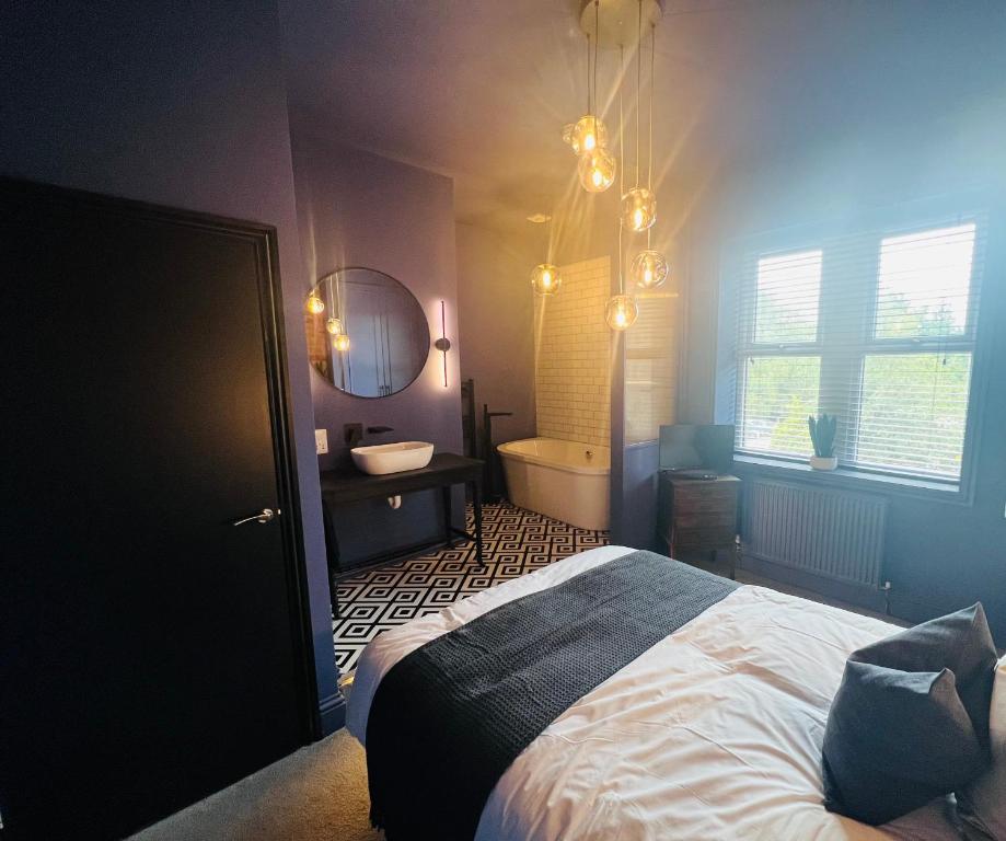 1 dormitorio con cama, bañera y lavamanos en Lancaster Place 18, en Carnforth