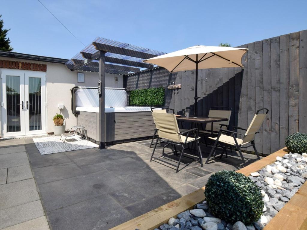 a patio with an umbrella and a table and chairs at 2 bed property in Howden 86817 in Scalby
