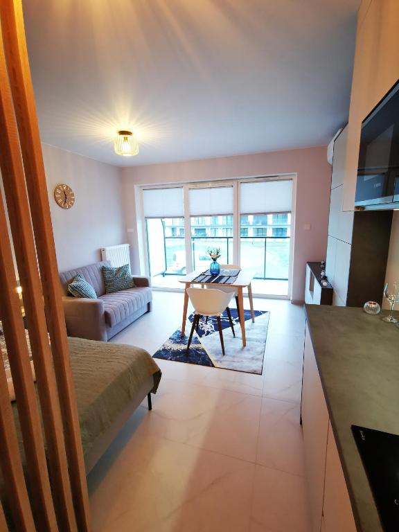 a living room with a table and a couch at Apolonia apartament II- SPA in Dziwnów