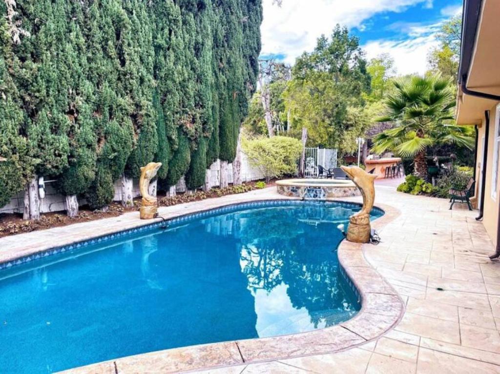 a swimming pool in a yard with trees at Elegant 6-Bedroom Haven in LA -ENC in Los Angeles