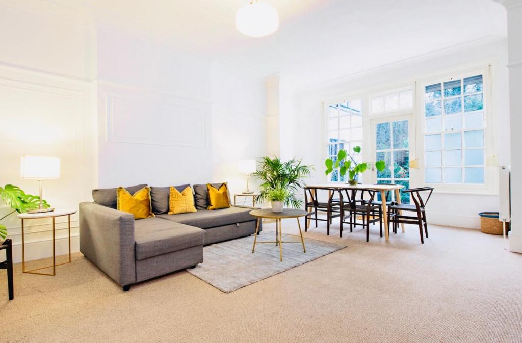 sala de estar con sofá y mesa en Spacious & Charming garden flat -Zone 2- Great for Central London access, en Londres