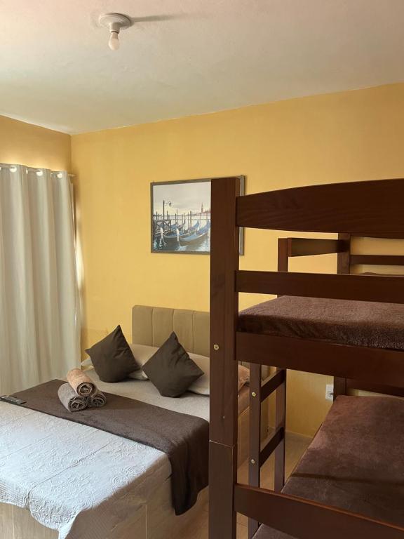 1 Schlafzimmer mit 2 Etagenbetten und 1 Etagenbett in der Unterkunft Suítes Brandi in Arraial do Cabo