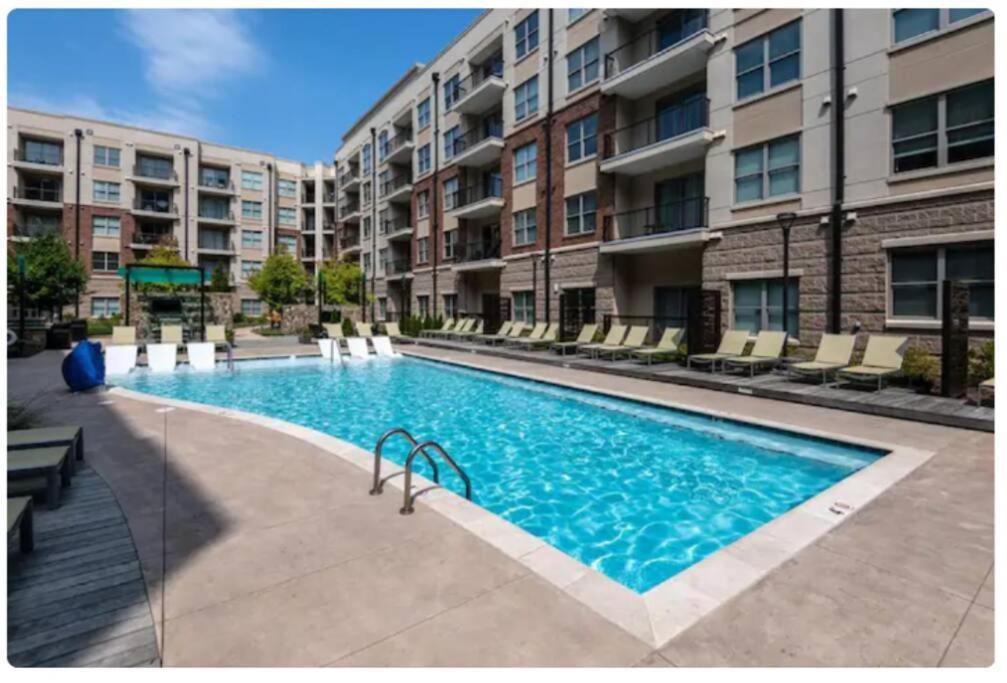 a swimming pool in front of a apartment building at League Flats Uptown at West Trade Street in Charlotte