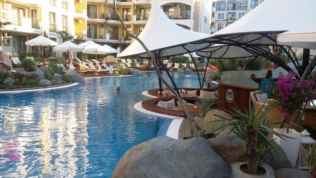 サニービーチにあるHarmony 5 Monte Carlo privat Apartmentのホテル内のスイミングプール(椅子、パラソル付)