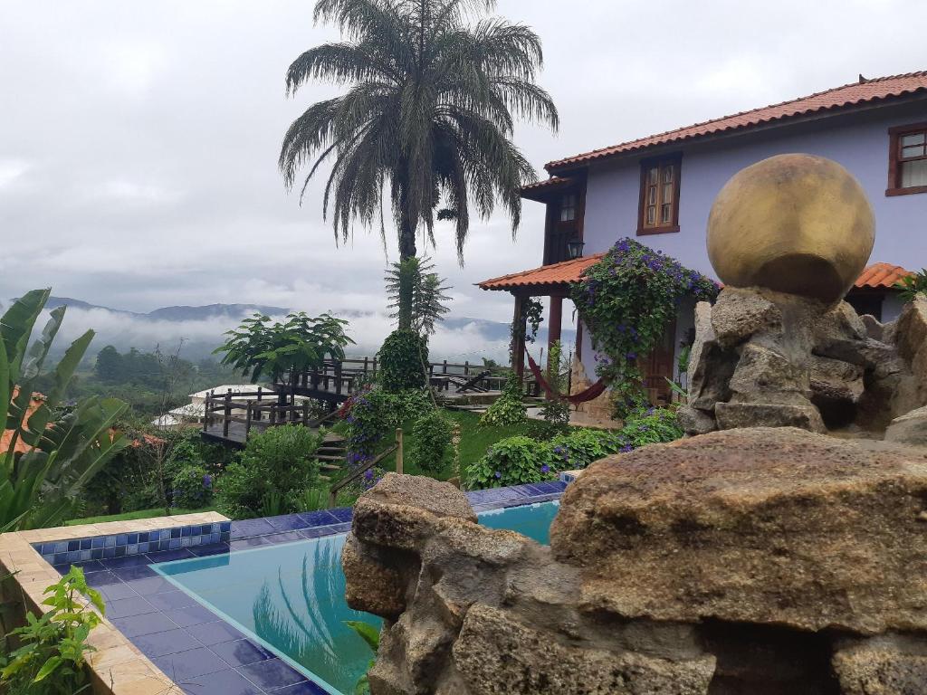 a resort with a swimming pool and a house at Pousada Residência Balestra in Tiradentes