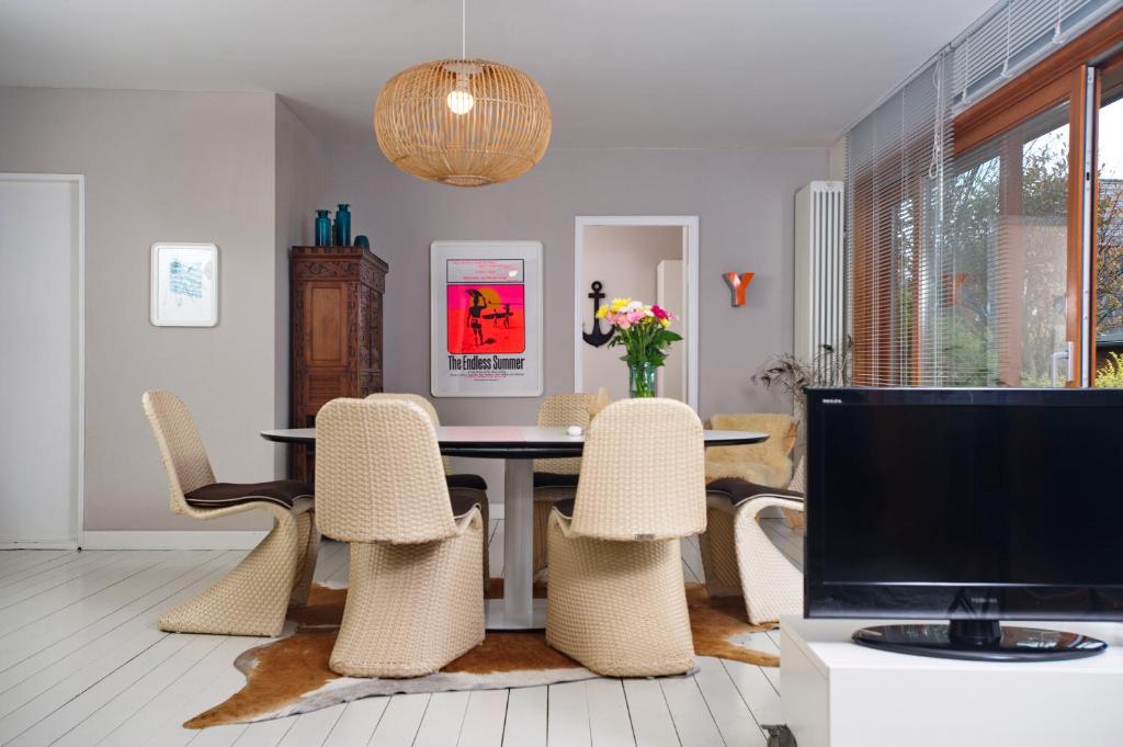 uma sala de jantar com mesa e cadeiras e uma televisão em Captain's Lounge - Bungalow XL em Westerland