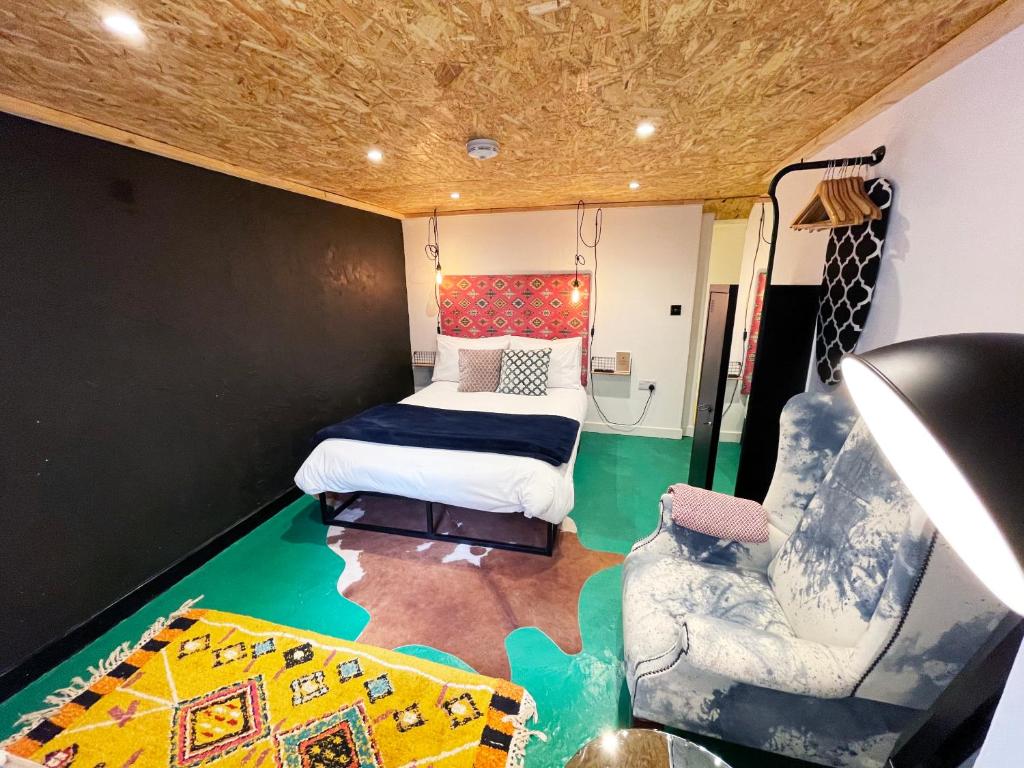 ein Zimmer mit einem Bett und einem Stuhl darin in der Unterkunft Fern Studio 1 Bedroom Apartment in Llangollen