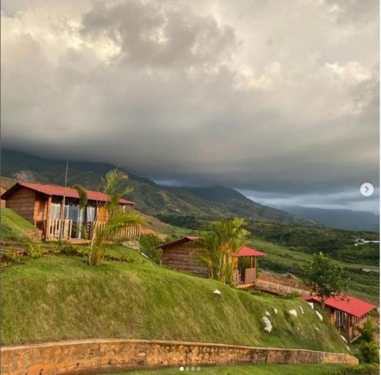 a house sitting on top of a grassy hill at Glamping Isaju , Santa Helena , Valle del Cauca in El Cerrito