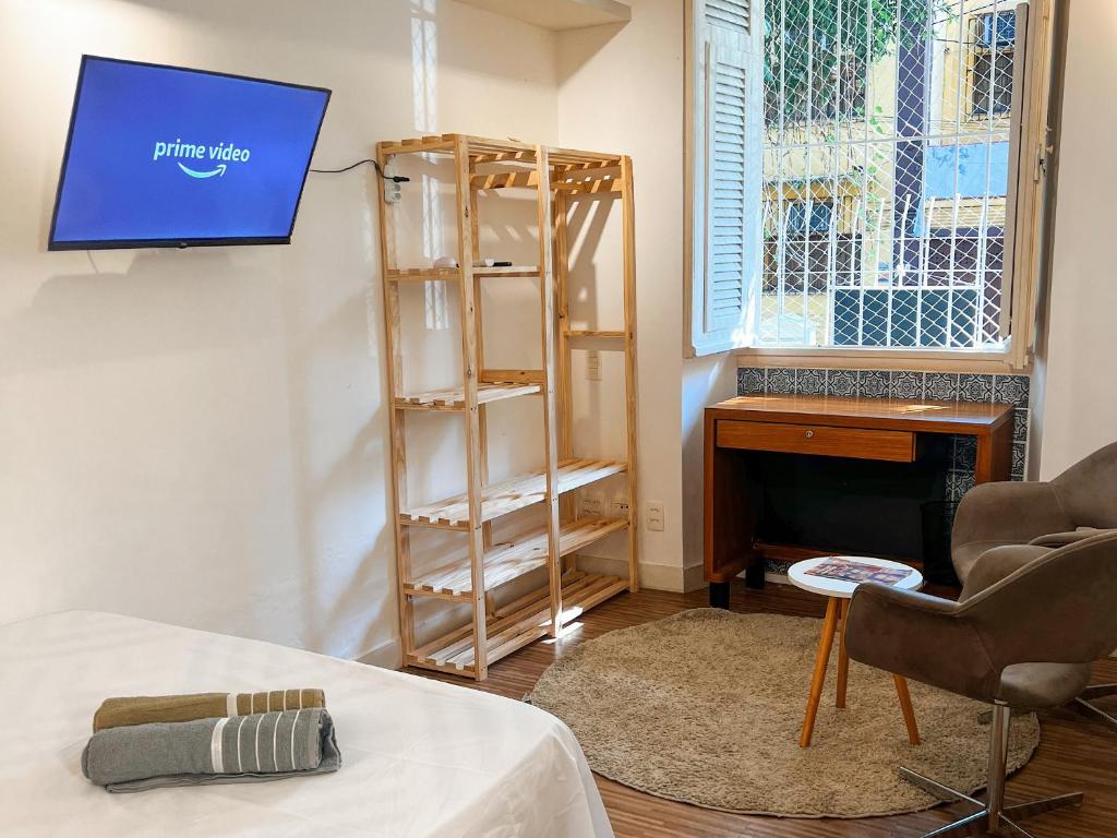 een kamer met een tv aan de muur en een bureau bij Hostel Pluto in Rio de Janeiro