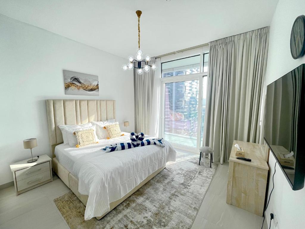 a white bedroom with a bed and a large window at 1 Bed Near Zabeel-Park Shiekh Zayed Rd world-Trade center in Dubai