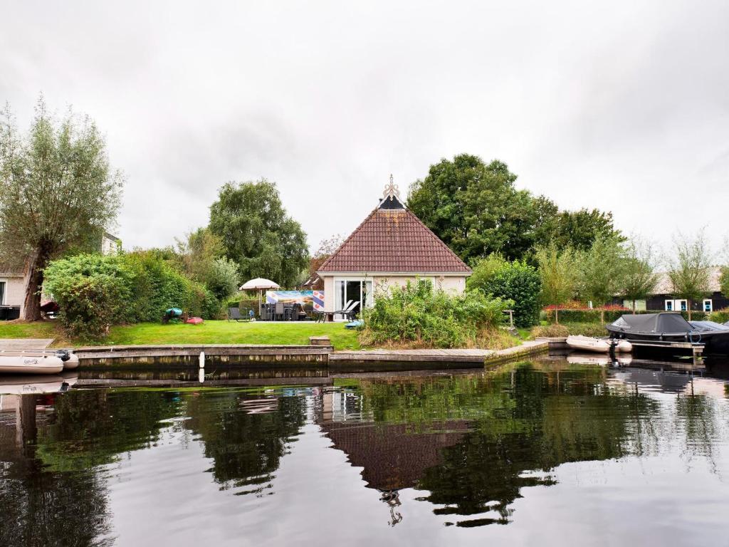 dom z odbiciem w zbiorniku wody w obiekcie Amazing holiday home in Friesland with Sauna and outdoor Spa w mieście Earnewâld