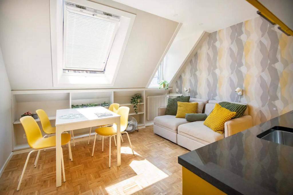 una cucina e un soggiorno con tavolo e sedie gialle di bedinBERN Aparthotel a Berna