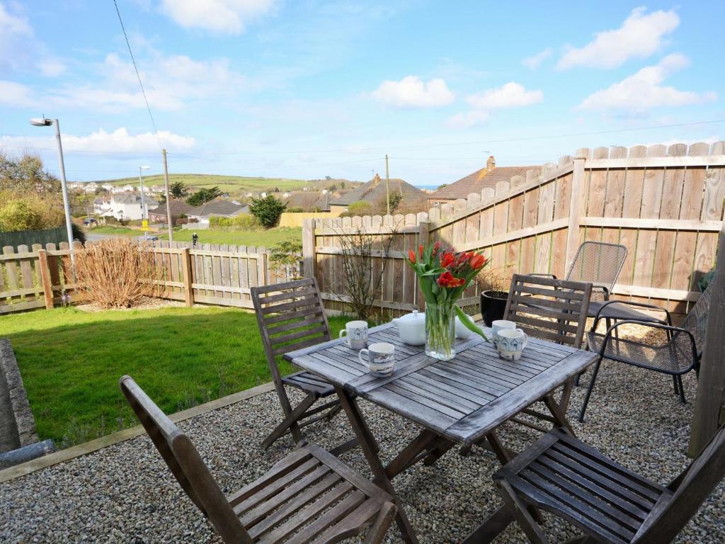 a wooden table with chairs and a vase of flowers at 2 Bed in Bude AGLET in Bude