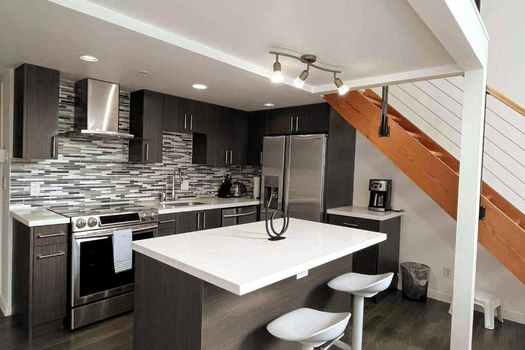 a kitchen with a white counter top in a room at Modern top-floor 1-bedroom loft with free parking in Vancouver