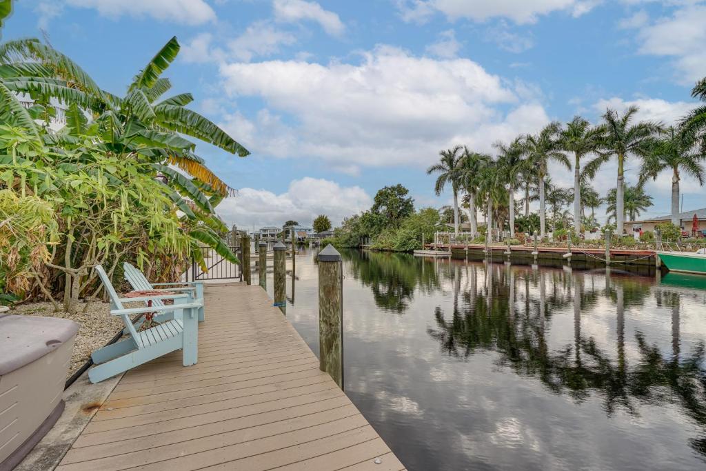 a wooden dock with a bench next to a river at Waterfront North Fort Myers Home with Private Pool! in North Fort Myers