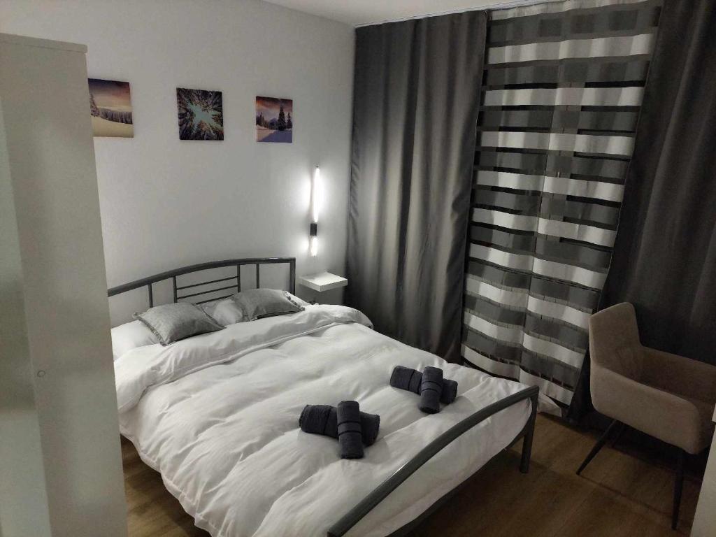 a bedroom with a large white bed and a chair at Olive Apartment in Lupeni