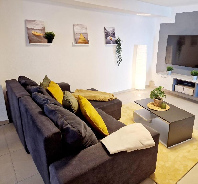 - un salon avec un canapé marron et des oreillers jaunes dans l'établissement Modernes Panorama-Domizil, à Schömberg