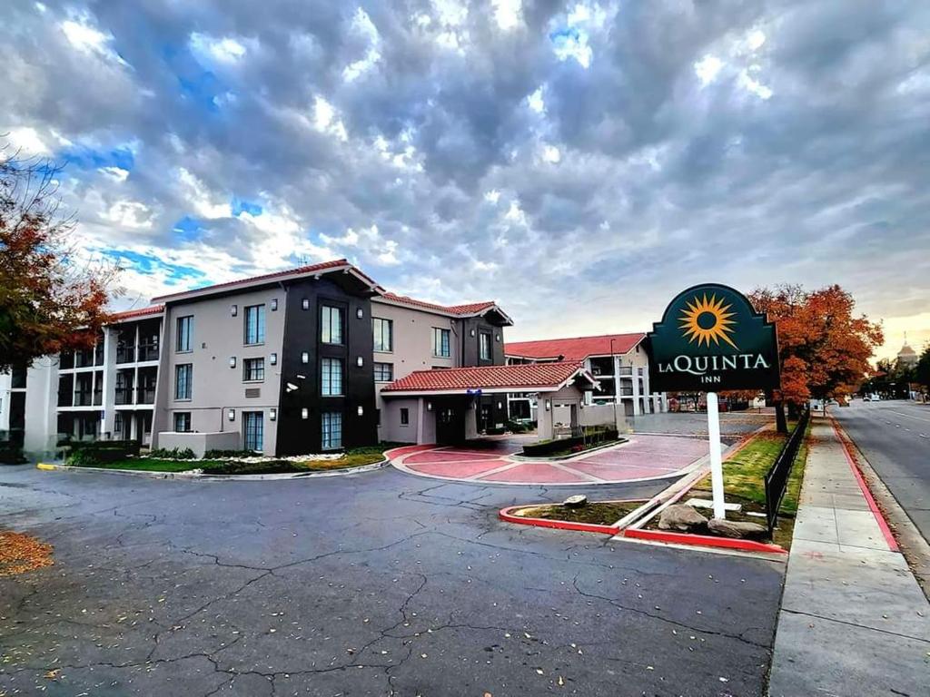 un hotel con un cartel frente a un edificio en La Quinta Inn by Wyndham Fresno Yosemite en Fresno