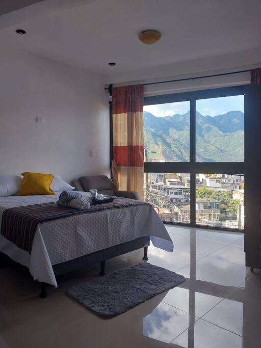 een slaapkamer met een bed en een groot raam bij Casa Beverly Xejuyu II in San Pedro La Laguna