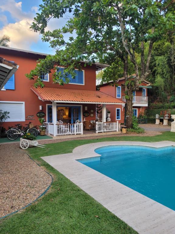 una casa con piscina frente a ella en La Belle Provence, en Itaipava