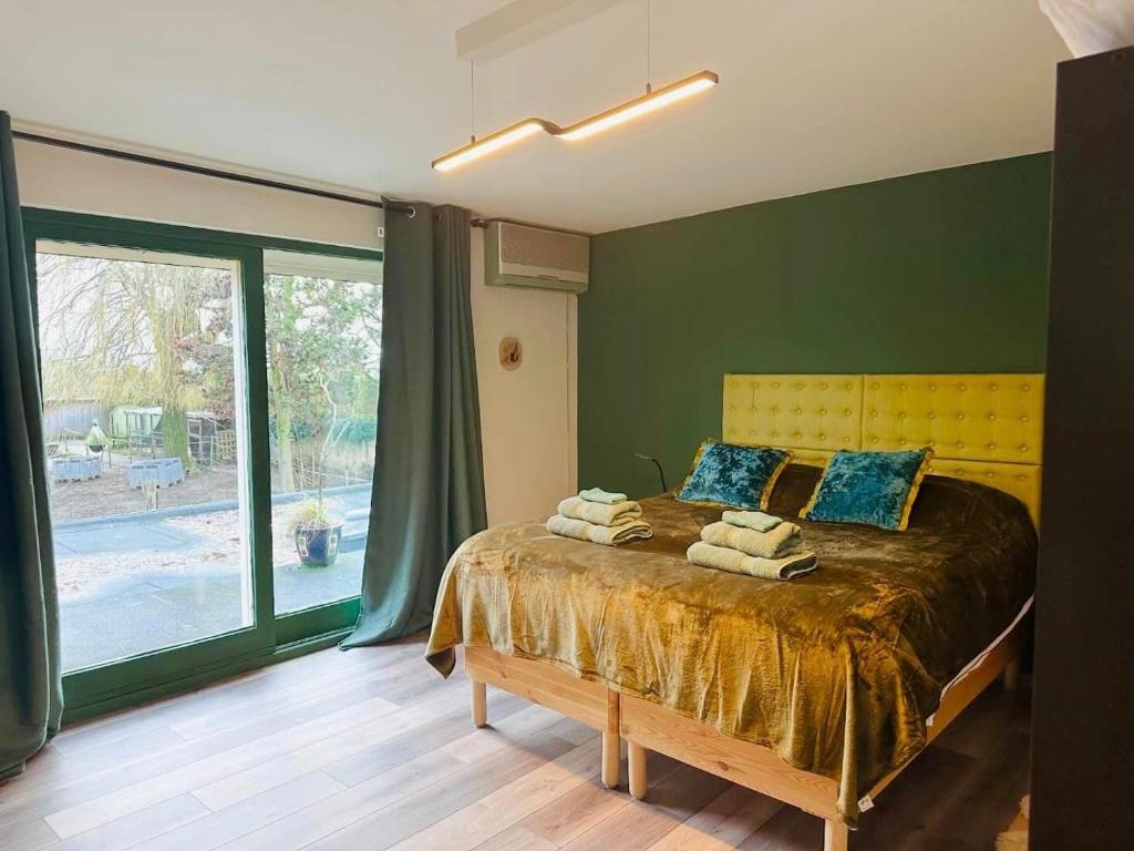 um quarto com uma cama e uma grande janela em Bed and breakfast aan de grens em Lanaken