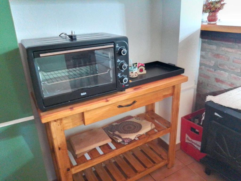 Un four micro-ondes est installé au-dessus d'une table en bois. dans l'établissement MAE, à Esquel