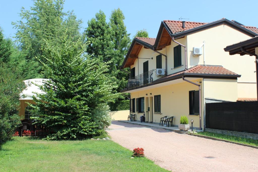 uma casa com uma árvore ao lado de uma entrada em Villa Giglio em Arsago Seprio