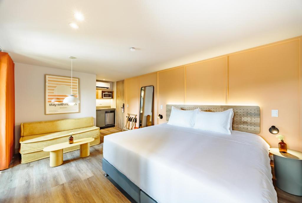 1 dormitorio con 1 cama blanca grande y 1 sofá en The Somos Flats Central Poblado, en Medellín