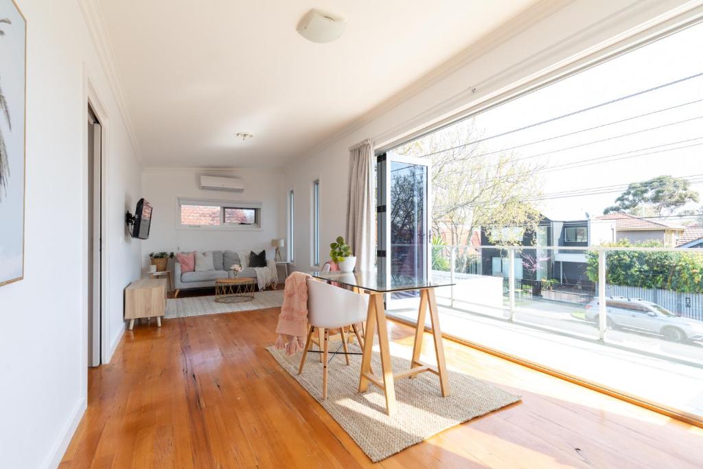 a dining room with a table and a large window at Elwood Star- Beachside Retreat in Melbourne