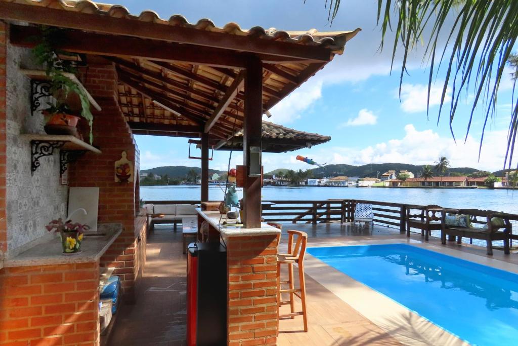 a poolside bar with a view of the water at Casa Flora in Cabo Frio