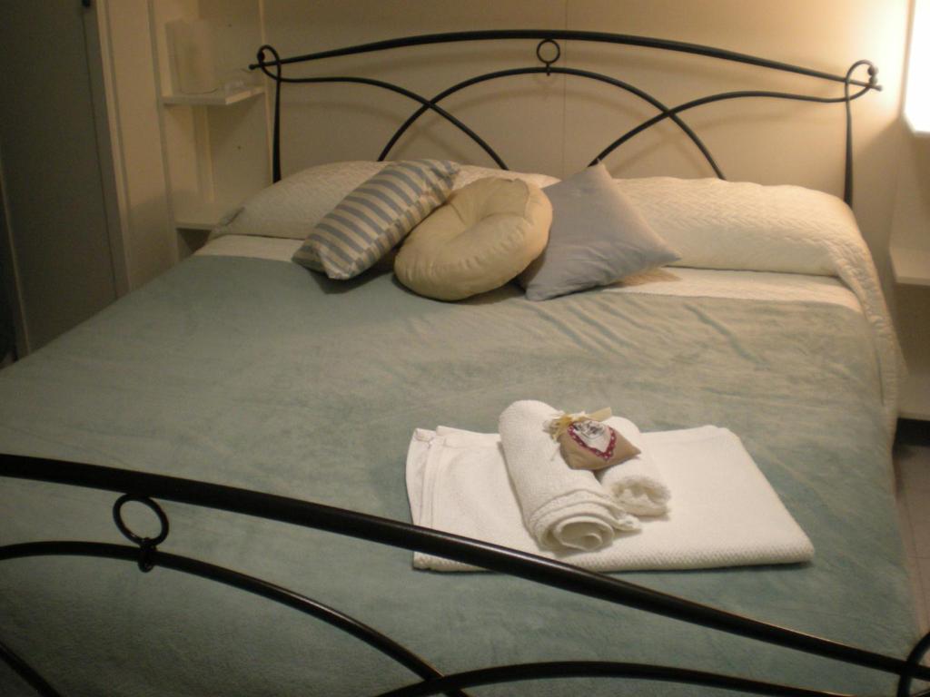 un letto con due cuscini e asciugamani di appartamento via ciatti a Perugia