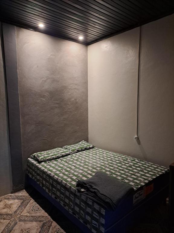 Cama pequeña en habitación con pared en Apartamento Mobilhado - Pousada Paraíso en Macapá