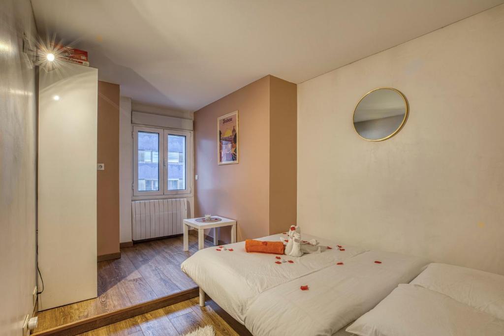 a bedroom with a bed with red rose petals on it at Spacious and cosy flat in Annecy
