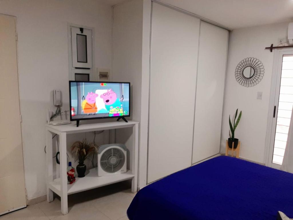 a living room with a tv on a white stand at Hermoso departamento céntrico! in San Miguel de Tucumán