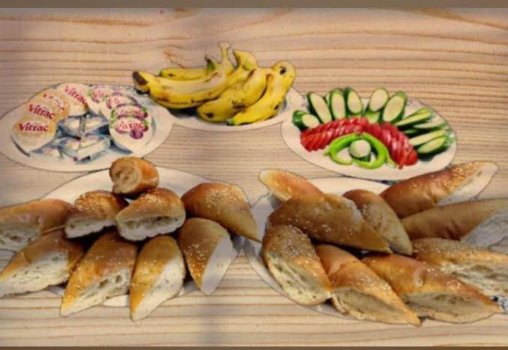 a table with plates of food and bananas and bread at Hotel Group in Cairo
