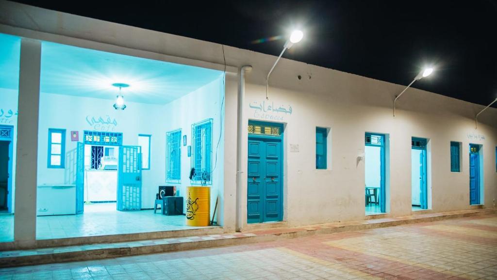 Una fila de puertas en un edificio por la noche en Jnayna Space, en Degache