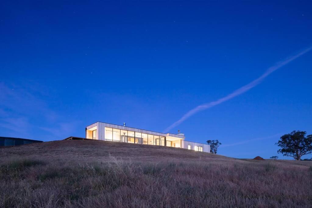 un edificio en la cima de una colina en un campo en Spectacular Kangaroobie Cabin en Borenore