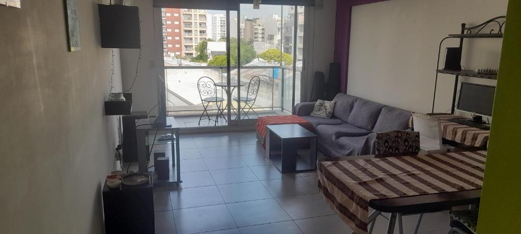 sala de estar con sofá y balcón en Donato anhelo departamento en caballito norte en Buenos Aires