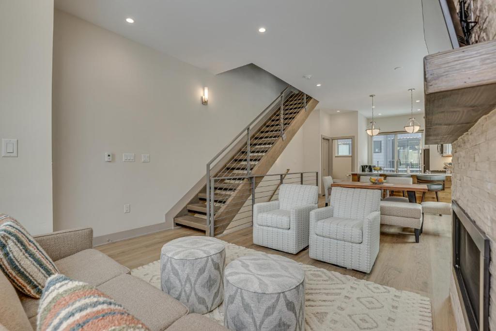 a living room with a couch and chairs and a staircase at Silverthorne Townhome with Hot Tub Walk to Town! in Silverthorne
