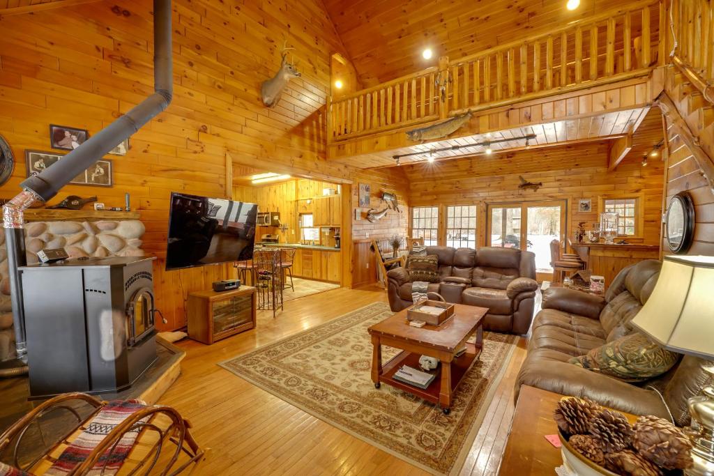 a living room with a couch and a fireplace in a cabin at Riverfront Luther Cottage with Year-Round Trail! in Luther
