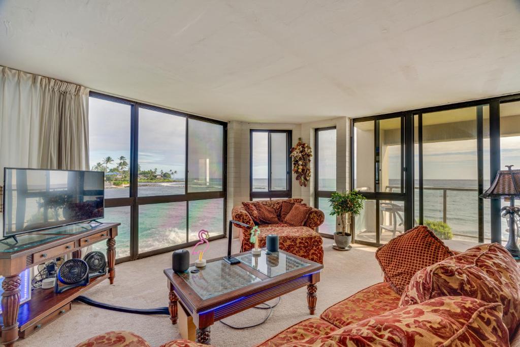 ein Wohnzimmer mit Möbeln und einem Flachbild-TV in der Unterkunft Colorful Poipu Condo with Expansive Ocean Views! in Koloa