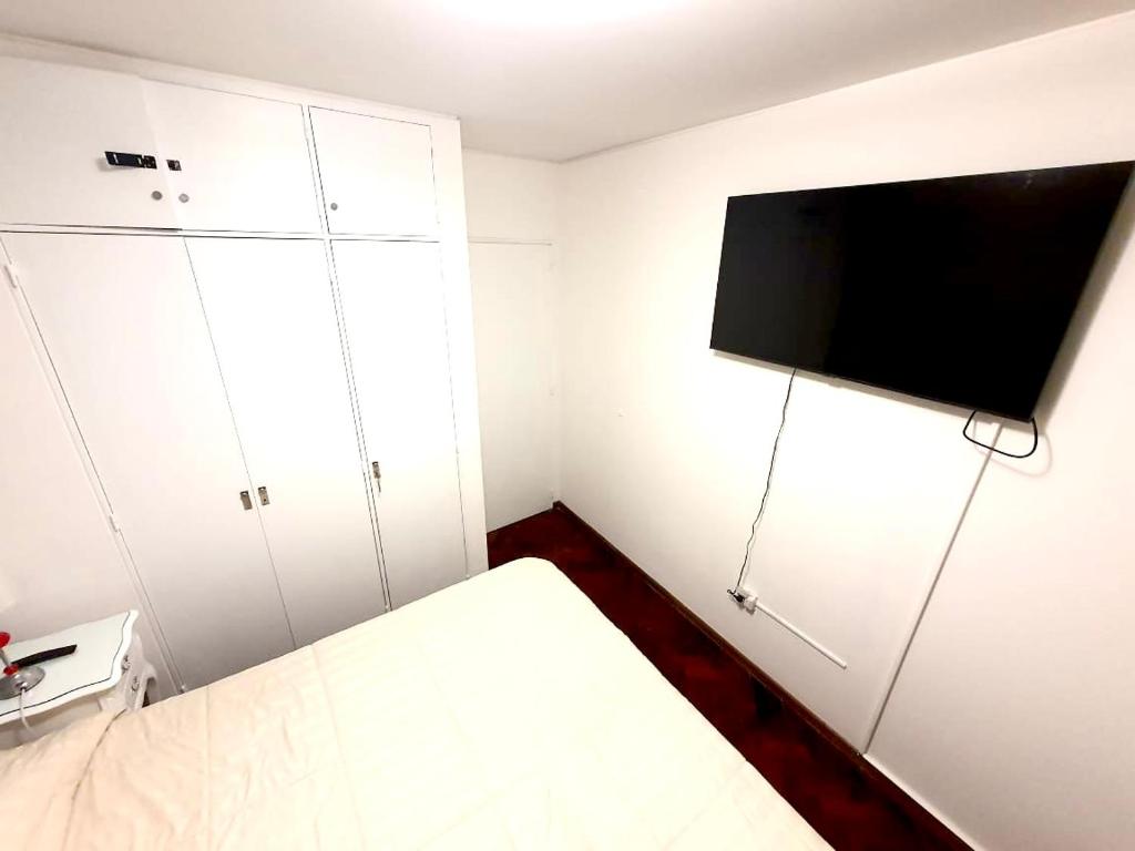 a small room with a bed and a flat screen tv at Hermoso, amplio y nuevo departamento, en la mejor ubicacion de la ciudad de Mendoza in Mendoza
